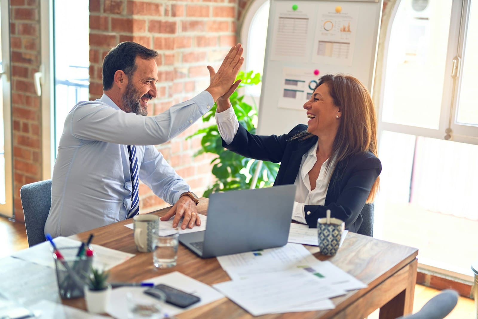 Two business owners reviewing their finances on a laptop